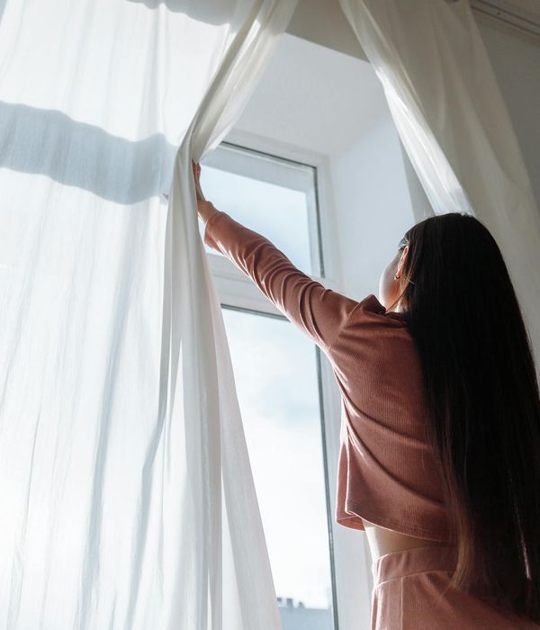 Woman feeling serene and energetic in a bright, calm room with gentle light.